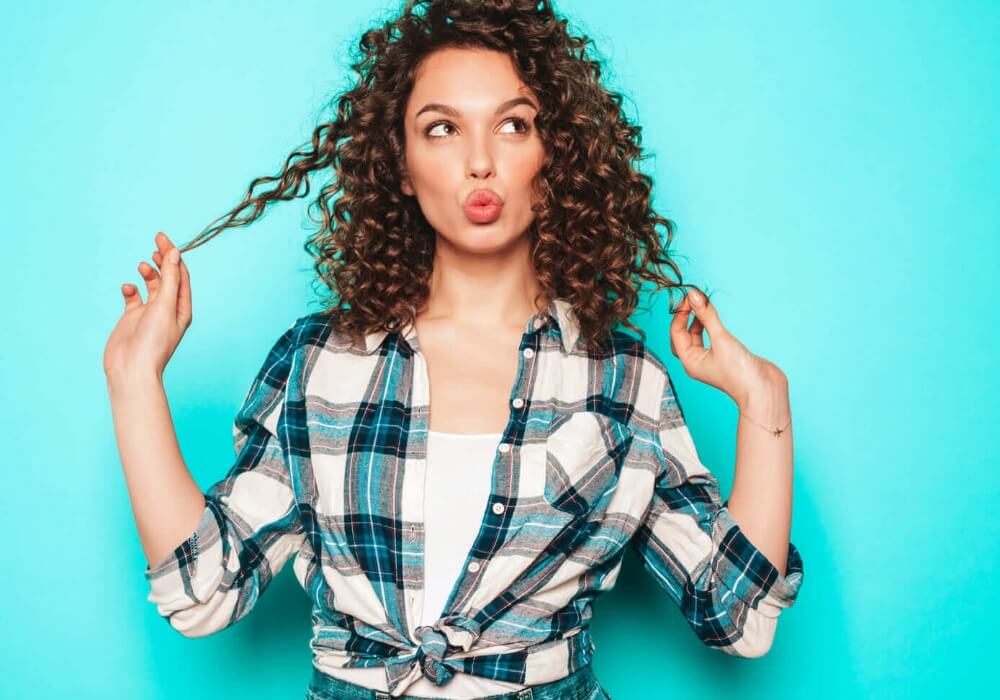 Mujer con cabello seco mostrando los 3 errores más comunes que resecan el cabello y cómo corregirlos con productos naturales