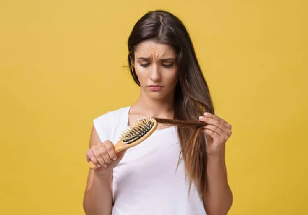 Mujer con cabello fino mostrando un tratamiento efectivo para la caída del cabello, incluyendo remedios naturales para fortalecer y nutrir el cabello