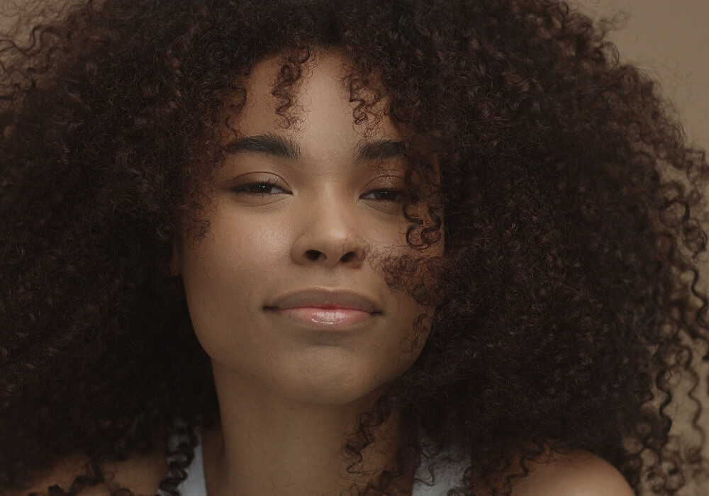 Primer plano de cabello afro sano mostrando la textura natural y la definición del rizo.